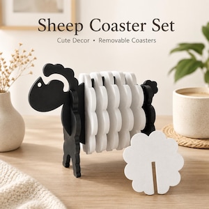 May include: A black and white sheep-shaped coaster set featuring a black frame shaped like a sheep's head and legs, holding several white, cloud-shaped coasters. The text "Sheep Coaster Set" and "Cute Decor • Removable Coasters" is visible.