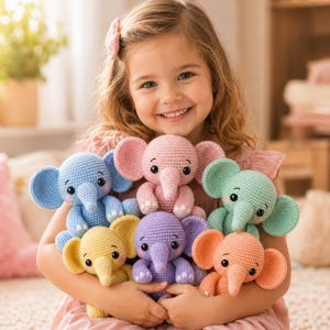 May include: A young girl smiles while holding a collection of colorful crochet elephant stuffed animals. The elephants are in shades of blue, pink, green, yellow, purple, and orange. Each has large ears, a trunk, and small black eyes.