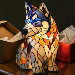 May include: A stained glass husky dog lamp with blue eyes, black nose, and a colourful mosaic design. The lamp features a sitting pose and is made of various colours including blue, orange, and yellow. The lamp is a decorative item.
