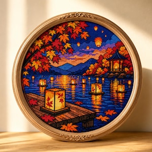 Könnte beinhalten: Eine kreisförmig gerahmte Kreuzstichstickerei, die eine nächtliche Szene mit einem Holzsteg, leuchtenden Papierlaternen auf einem See, einer Pagode und herbstlichen Ahornbäumen mit roten und orangefarbenen Blättern vor einem blauen Himmel zeigt.