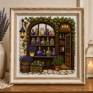 May include: A framed cross-stitch embroidery depicting a shop interior with shelves filled with colorful glass bottles, a small owl, and potted lavender plants. The scene features a hanging lantern, an open wooden door, and green ivy vines.