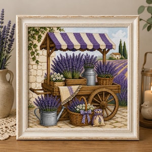 Könnte beinhalten: Ein gerahmtes Kreuzstichbild, das einen hölzernen Karren voller violetter Lavendelbündel, weißer Gänseblümchen und Metallbehälter zeigt. Der Karren hat ein violett-weiß gestreiftes Vordach und steht vor einer Steinmauer und einem Lavendelfeld.