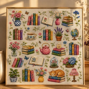 May include: A framed cross-stitch embroidery on linen fabric featuring a grid of colorful illustrations including stacks of books, floral arrangements in vases, a pink teapot, a globe, a sleeping orange tabby cat, and a small lamp.
