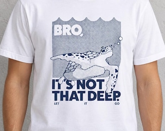May include: A white short-sleeved t-shirt featuring a dark blue graphic of a sea turtle swimming upward. The text reads BRO, IT'S NOT THAT DEEP. LET IT GO. The design includes a dotted background pattern and bubbles rising from the turtle.