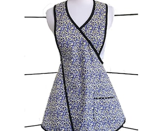 May include: A yellow and blue floral print apron with a black trim and a single pocket. The apron has a V-neck and a wrap-around style.