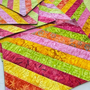 May include: A collection of colorful, triangular fabric pieces with a striped pattern. The stripes are in shades of pink, yellow, orange, and green. The fabric appears to be quilted, with visible stitching.