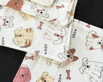 May include: A set of four white cotton dishcloths with a repeating pattern of brown, pink, and yellow cartoon dogs wearing different outfits. The text "WGOOF" is repeated throughout the pattern.