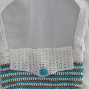 May include: White crocheted shoulder bag with brown and white stripes and a turquoise bottom. The bag has a white crocheted flap with a turquoise button.