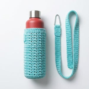 May include: A red water bottle with a silver cap is encased in a light blue crocheted sleeve. A matching light blue crocheted strap with a silver carabiner clip is next to the bottle. The items are on a white background.