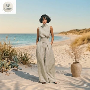 May include: A sleeveless, light beige jumpsuit featuring a high mock neck, a fitted waist with a wide band, and wide-leg trousers. The garment is constructed from a textured fabric and includes a subtle pleat detail at the front of the pants.