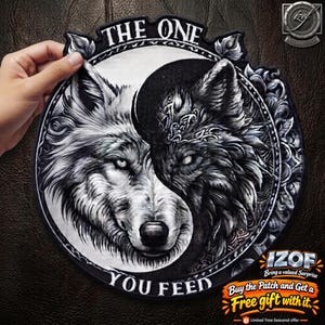 May include: A circular embroidered patch featuring a yin-yang design composed of a white wolf head on the left and a black wolf head on the right. The text THE ONE YOU FEED is arched around the border, which is decorated with ornate floral patterns.
