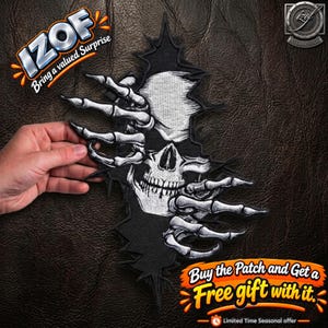 May include: An embroidered patch featuring a white skull emerging from a black background, framed by two skeletal hands with long fingers. The design is rendered in high-contrast black and white thread, creating a detailed, textured appearance.