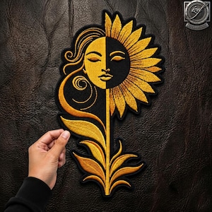 May include: An embroidered patch featuring a split design of a sun and a sunflower. One side shows a golden sun face with swirling lines, while the other side displays a dark sunflower petal arrangement. The design is rendered in gold and black thread.