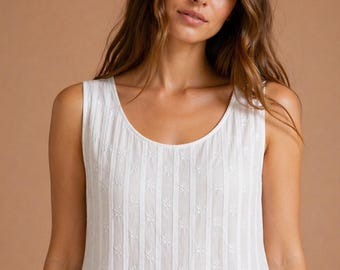 Camisola Lizzie em algodão branco estilo vitoriano, sem mangas, com corpete plissado e bordado de margaridas.