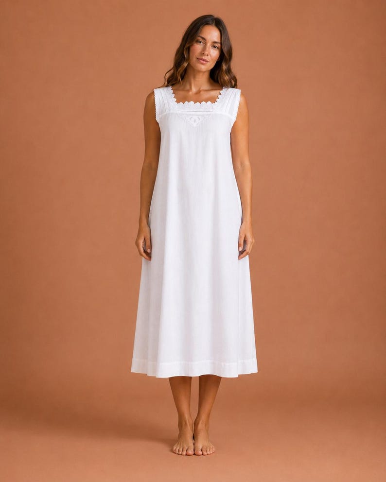 May include: A sleeveless white nightdress featuring a square neckline with scalloped lace trim and vertical pintuck detailing on the bodice. The garment has a loose, flowing silhouette that extends to the mid-calf, crafted from a solid white fabric.