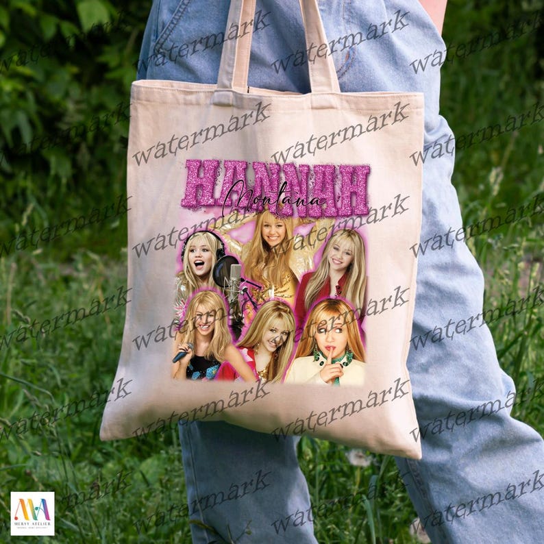 K&ouml;nnte beinhalten: Eine beigefarbene Tragetasche mit einer Collage von Bildern von Hannah Montana und dem Text "Hannah Montana" in rosa Glitzer. Die Tasche hat zwei Griffe. Die Person, die die Tasche h&auml;lt, tr&auml;gt eine blaue Jeans.