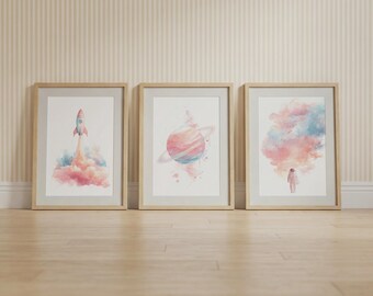 Conjunto de 3 pôsteres infantis com tema espacial rosa – Menina astronauta, foguete e planeta.