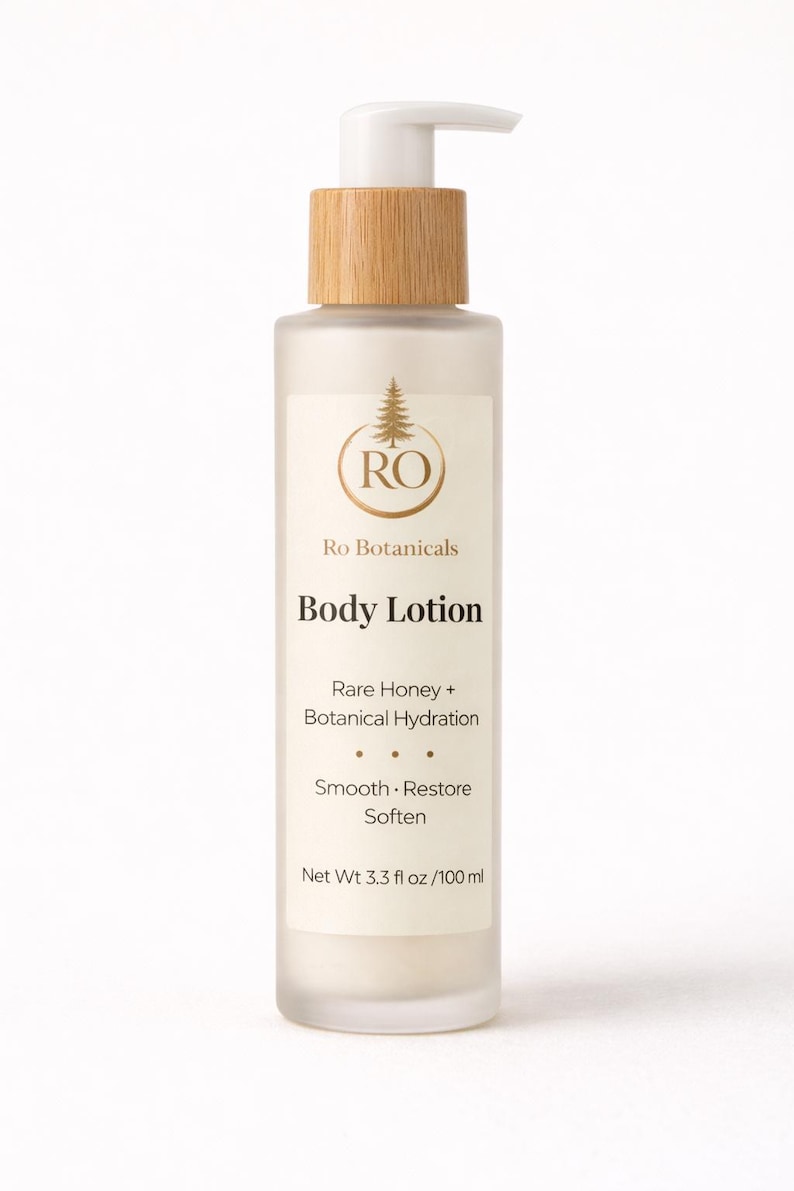 Pu&ograve; includere: Una bottiglia di vetro smerigliato di lozione per il corpo Ro Botanicals con tappo e pompa in legno. L'etichetta include il testo "Rare Honey + Botanical Hydration" e "Smooth, Restore, Soften". La bottiglia contiene 100 ml.