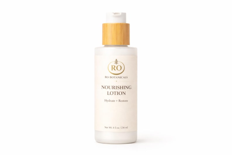 Pu&ograve; includere: Flacone bianco di lozione nutriente RO Botanicals con tappo in bamb&ugrave; marrone chiaro. L'etichetta include il nome del marchio, un logo e le parole "Nourishing Lotion" con "Hydrate + Restore" sotto. Il flacone contiene 236 ml.