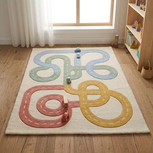 Puede incluir: Una alfombra rectangular de color blanquecino con un diseño de carreteras coloridas. Las carreteras son de color rojo, amarillo, verde y azul. Pequeños coches de juguete están colocados sobre la alfombra, realzando el tema lúdico. La alfombra está en una habitación con una ventana y una estantería de madera.