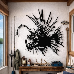 May include: A black metal anglerfish wall art piece with detailed features, mounted on a textured white wall. The artwork features sharp teeth and spiky fins, creating a striking nautical theme. The room includes fishing rods, a lantern, and decorative items.