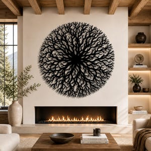 Peut inclure: Une grande &oelig;uvre d'art murale circulaire en m&eacute;tal noir repr&eacute;sentant un arbre stylis&eacute; ou un motif de branches. L'&oelig;uvre est mont&eacute;e sur un mur de couleur neutre au-dessus d'une chemin&eacute;e avec un feu incandescent. La pi&egrave;ce a une esth&eacute;tique moderne et minimaliste.