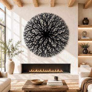 Peut inclure: Une grande &oelig;uvre d'art murale circulaire en m&eacute;tal noir repr&eacute;sentant un motif de branches d'arbre. L'&oelig;uvre est fix&eacute;e sur un mur blanc au-dessus d'une chemin&eacute;e. La pi&egrave;ce pr&eacute;sente des tons neutres, des poutres en bois et une esth&eacute;tique moderne.