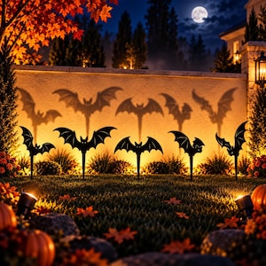 Peut inclure: Cinq piquets de jardin en forme de chauve-souris noirs sont disposés en rangée sur une pelouse. Chaque piquet présente une base pointue et la silhouette d'une chauve-souris aux ailes déployées. Une lumière chaude éclaire le mur.