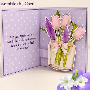 Puede incluir: Una tarjeta de felicitación con fondo violeta claro y lunares blancos. La tarjeta muestra una ilustración desplegable de un frasco de cristal con tulipanes rosas y ramitas moradas, atado con un lazo rosa. El texto dice: Hope your special day is as wonderful, bright, and amazing as you are. Have the best birthday ever!