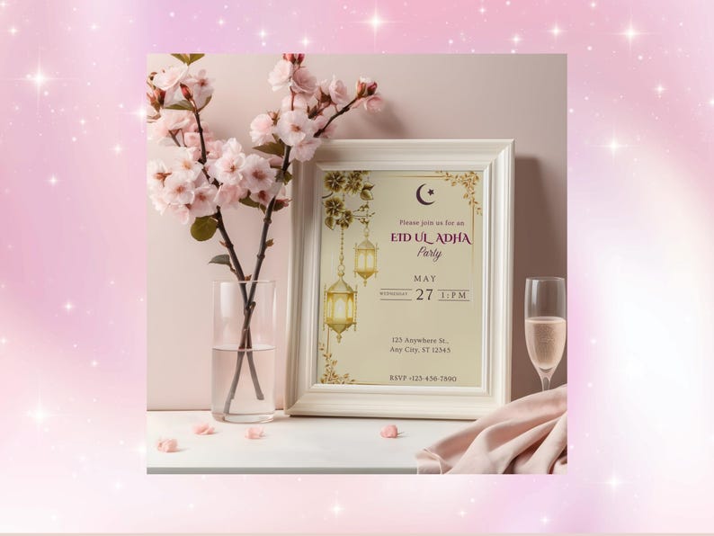 May include: A framed invitation for an Eid Ul Adha party, with a crescent moon and lantern design. The invitation is displayed with a vase of pink flowers, a champagne flute, and a pink cloth. The text reads "Eid Ul Adha Party, May 27, 1 PM."