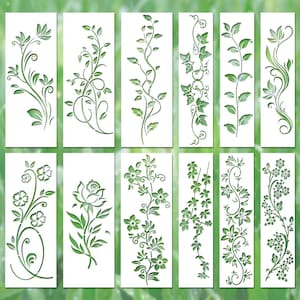 May include: A set of twelve rectangular stencils featuring various botanical designs including climbing vines, leafy branches, and floral patterns. Each white stencil displays a unique cutout pattern of plants, leaves, and flowers in a vertical orientation.