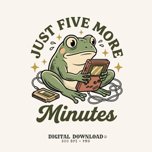 May include: A green frog illustration holding a handheld video game console with a game cartridge nearby. The text reads JUST FIVE MORE MINUTES, DIGITAL DOWNLOAD, 300 DPI + PNG. The design features stars and sweat drops in a retro graphic style.