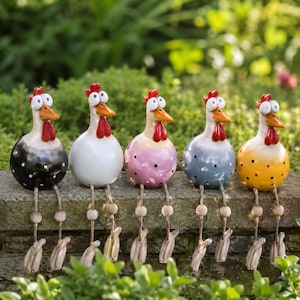 May include: Five decorative ceramic chicken ornaments with red crests, orange beaks, and dangling wooden legs. The chickens are painted in various colours: black with white spots, white, pink with black spots, blue with black spots, and yellow with red spots. They sit on a stone wall.