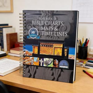May include: A spiral-bound book titled "Rose Book of Bible Charts, Maps & Time Lines" with a dark cover featuring illustrations of ancient architecture and religious symbols. The book has a "10th Anniversary" emblem.