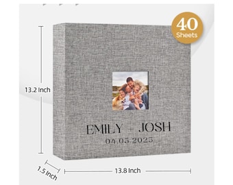May include: A square gray fabric photo album featuring a central window for a photograph, the text "EMILY + JOSH" and "04.05.2025", and a gold circular badge stating "40 Sheets". Dimensions are 13.2 inches high, 13.8 inches wide, and 1.5 inches deep.