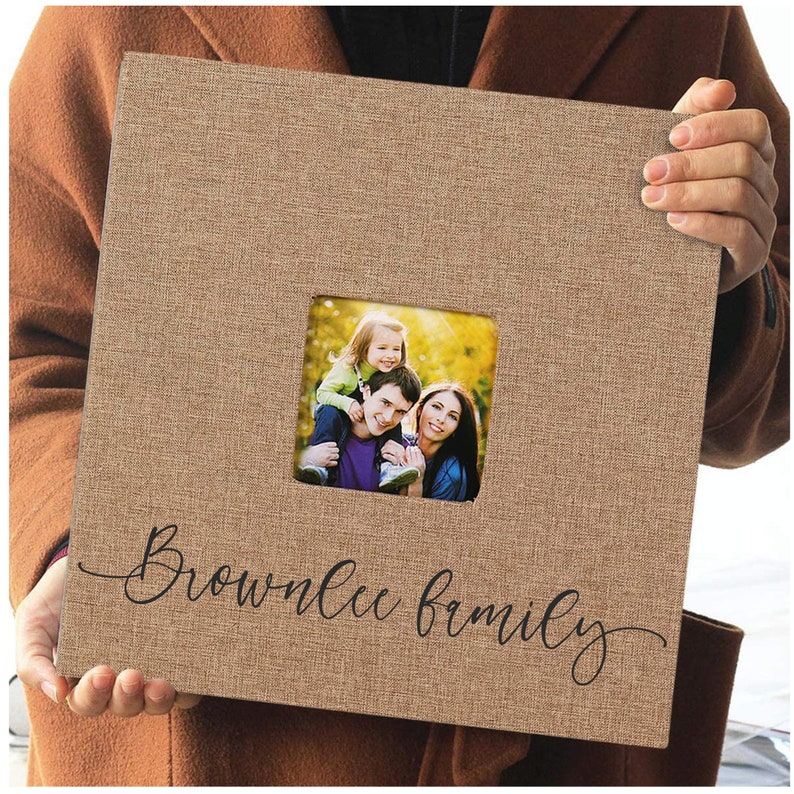 May include: A brown burlap photo album with a window for a photo. The album has the text "Brownlee Family" written in black cursive script.