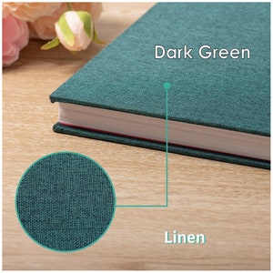 May include: A dark green linen-covered journal with the text "Dark Green" printed on the cover. The journal has a white spine and red stitching.