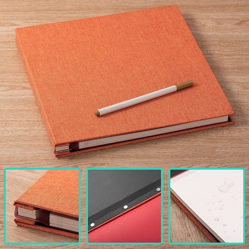 K&ouml;nnte beinhalten: Ein orangefarbenes, mit Stoff bezogenes Hardcover-Journal mit einem wei&szlig;en Stift darauf. Das Journal hat einen roten R&uuml;cken und ein schwarzes Lesezeichenband. Das Journal ist auf einer leeren Seite mit Wassertropfen ge&ouml;ffnet.