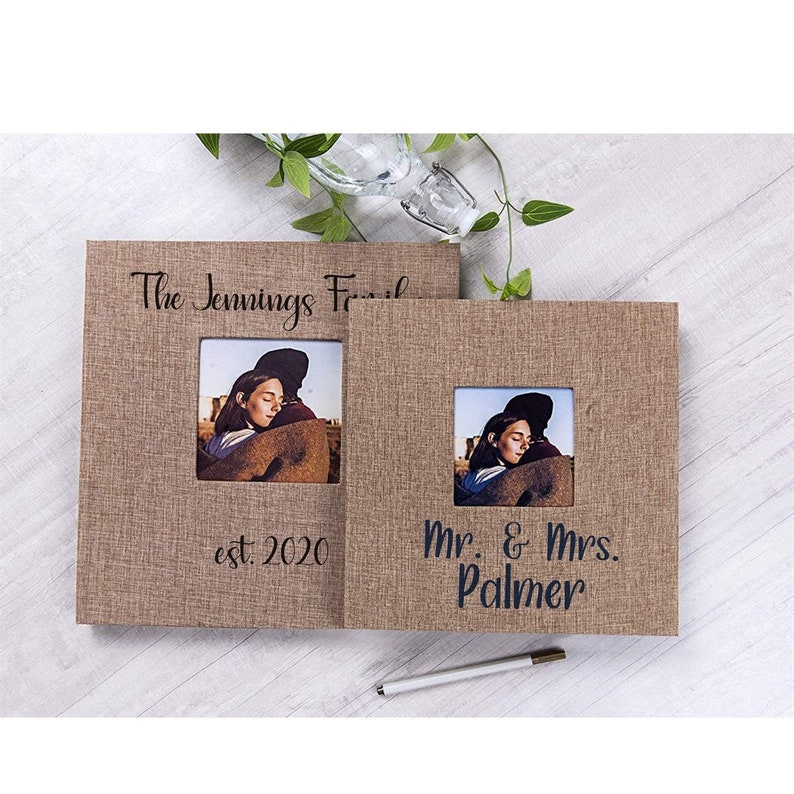 May include: Two brown burlap photo albums with black text. The first album says "The Jennings Family est. 2020" and the second album says "Mr. & Mrs. Palmer".