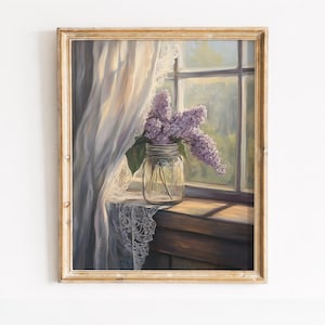 Peut inclure: Une impression d'art encadrée représentant un bocal en verre transparent rempli de fleurs de lilas violettes. Le bocal est posé sur un rebord de fenêtre en bois à côté d'un rideau en dentelle blanche. La scène est éclairée par la lumière naturelle.