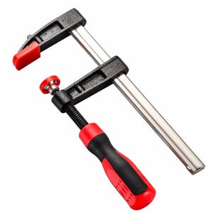 May include: A black and silver bar clamp with a red handle and red clamp pads. The clamp has a screw mechanism for adjusting the clamping pressure. The handle is black and red, and the clamp pads are red.