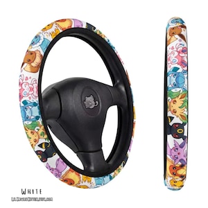 May include: A white steering wheel cover featuring a repeating pattern of colourful cartoon creatures. The cover is shown on a black steering wheel and as a side profile view. The text "WHITE" and "LILKAWAIIKITTEN.ETSY.COM" is printed below.