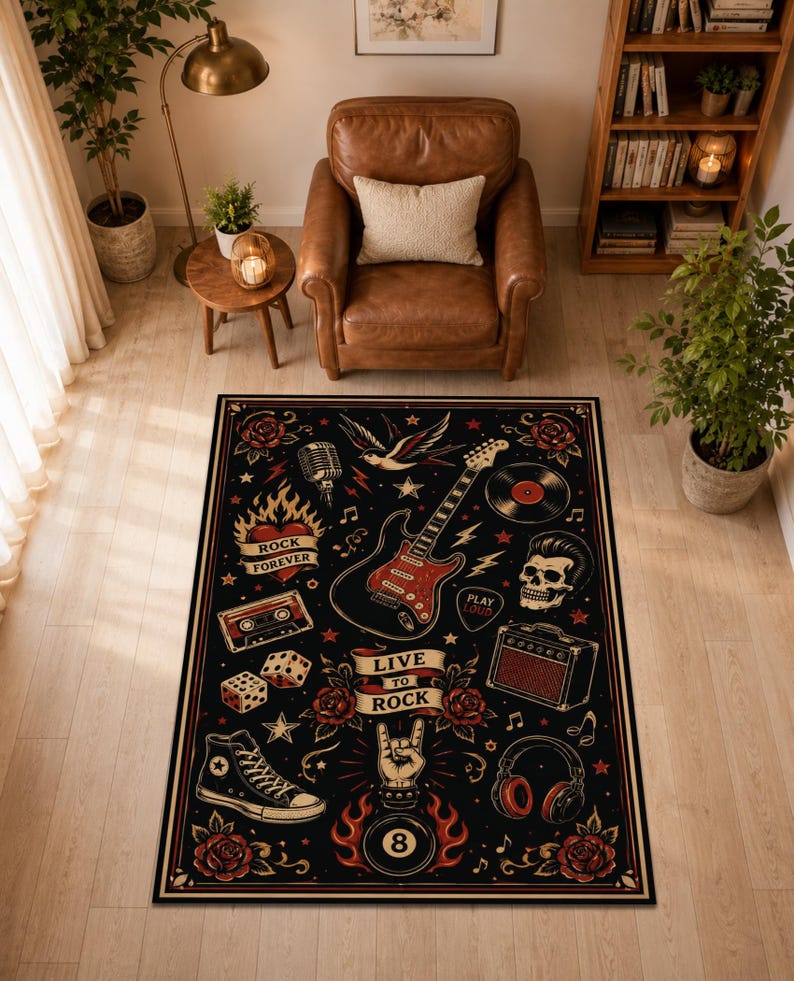 May include: A rectangular area rug featuring a black background with a rock and roll theme. The design includes a red electric guitar, a skull, a microphone, a cassette tape, dice, headphones, an amplifier, a sneaker, and an eight ball. Text reads "LIVE TO ROCK", "ROCK FOREVER", and "PLAY LOUD".