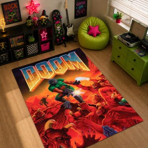 Może przedstawiać: Prostokątny dywan z napisem "DOOM" w stylu 3D. Dywan przedstawia scenę z gry wideo, z postacią ubraną na zielono walczącą z czerwonymi demonami na tle ognistego tła. Dywan leży na drewnianej podłodze.