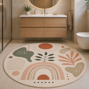 Può includere: Un tappeto rotondo con sfondo color crema e un motivo stampato di forme astratte, tra cui un rametto di foglie verde al centro, un arcobaleno color terracotta e varie forme organiche nelle tonalità verde salvia, beige e arancione bruciato.