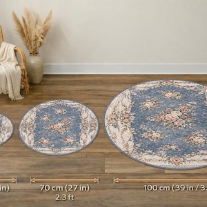 K&ouml;nnte beinhalten: Drei runde Teppiche mit einem Blumendesign in Blau-, Rosa- und Cremet&ouml;nen. Der gr&ouml;&szlig;te Teppich hat einen Durchmesser von 100 cm, der mittlere Teppich 70 cm und der kleinste 40 cm. Die Teppiche sind auf einem Holzboden ausgestellt.