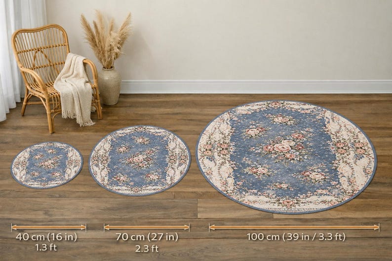 K&ouml;nnte beinhalten: Drei runde Teppiche mit einem Blumendesign in Blau-, Rosa- und Cremet&ouml;nen. Der gr&ouml;&szlig;te Teppich hat einen Durchmesser von 100 cm, der mittlere Teppich 70 cm und der kleinste 40 cm. Die Teppiche sind auf einem Holzboden ausgestellt.