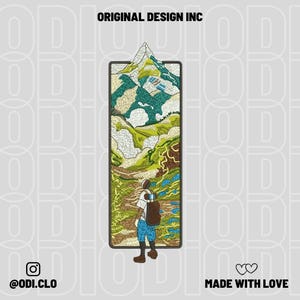 May include: Embroidered design featuring a mountain landscape within a rectangular frame. A person with a backpack is depicted hiking through the landscape. The design includes the text "ORIGINAL DESIGN INC", "@odi.clo", and "MADE WITH LOVE".