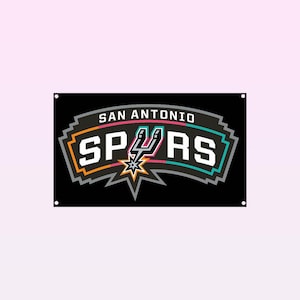 May include: Black banner featuring the San Antonio Spurs logo. The logo includes the team name, "SPURS," in white, outlined in teal, orange, and gray. The words "SAN ANTONIO" are above the team name in white. A star and spur graphic is in the center.
