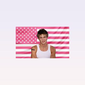 May include: A person wearing a white tank top and a necklace, with a pink and white American flag background. The person has a tattoo on their arm.